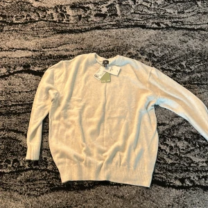 Vit stickad tröja från H&M - Snygg vit stickad tröja från H&M i relaxed fit. Tröjan har rund halsringning, ribbade muddar och är tillverkad i mjukt material. Perfekt för lager-på-lager och passar till allt. Enkel och clean stil som funkar året runt.