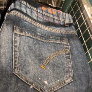  Dondup  - Snygga blå jeans från Dondup. Jeansen har orange kontrastsömmar, unika detaljer på bakfickorna och diskreta slitningar samt färgstark som gör dom lite extra stiliga. Perfekta för dig som gillar lite stiligare jeans 