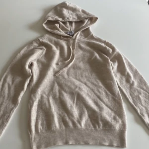 Beige hoodie i ull från Ahlqvist XS - Riktigt snygg Kashmir hoodie från Ahlquist Clothing i  riktigt bra skick. Använd fåtal gånger men säljer den nu för den var för liten. Storleken är xs men är ganska liten i storleken. Pris kan diskuteras