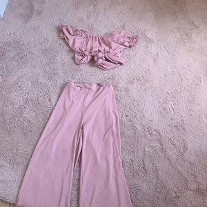 Ljusrosa omlott topp med puffärm - Supersöt ljusrosa omlott topp med puffiga korta ärmar och knytband i midjan. Toppen har en ribbad struktur och elastisk halsringning som kan bäras offshoulder. Perfekt för dig som gillar romantisk och trendig stil. Köpt i I Italien så de står varumärke från HM men de rätta är Italien❤️