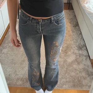 Bootcut jeans - As coola jeans med detaljer i storlek 28, personen på bilden är 172 för referens. De är något slitna nere vid byxbenet men det är inget man tänker på plus det går att sy. Är öppen för prisförslag 💕