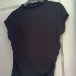 Svart t-shirt  - Svart tröja från lager med sömmar in mot midjan 