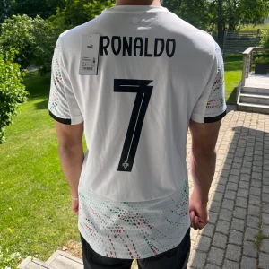 Portugal bortatröja 24/25 - Portugal bortatröja från Unisport med Ronaldo tryck. Helt oanvänd, kunde ej returnera pga. tryck. Säljer för att jag köpte 2 olika storlekar till min pojkvän. Köpt för 1500kr, har kvitto från Unisport digitalt. 