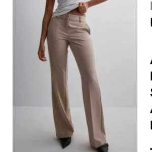 Beiga bootcut kostymbyxor - Snygga beiga kostymbyxor med bootcut-snitt Byxorna har hällor för bälte, fickor fram och bak samt stängs med dragkedja och knapp. Tillverkade i ett mjukt bomullsmaterial som ger en clean och stilren look.