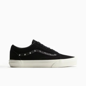 Svarta sneakers med nitar från Vans - Svarta Vans sneakers i klassisk modell med vit sula och snygga silverfärgade nitar längs sidan. Skorna har snörning och är tillverkade i mocka och textil