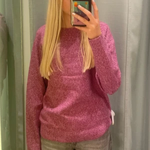 Lila stickad tröja med rund hals - Mysig lila stickad tröja med rund hals och långa ärmar. Tröjan har en relaxed passform och ribbade muddar vid ärmslut och nederkant. Perfekt för att hålla sig varm under kyliga dagar. Den är i fint skick och endast använd fåtal gånger. Färgen på tröjan finns inte längre att köpa hos Vero Moda. 