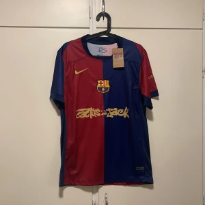 FC Barcelona x Cactus Jack Nike tröja L - FC Barcelona x Cactus Jack matchtröja från Nike i storlek L. Halva tröjan är vinröd och andra halvan marinblå, med guldiga detaljer och tryck. Tillverkad i Dri-FIT-material som andas. Klassisk klubbsköld på bröstet och unika samarbetstryck.