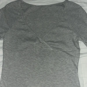 Grå långärmad tröja - En grå långärmad tröja med en V neck, tröjan är i bra skick men lappen från tröjan finns inte kvar. En perfekt tröja för vilken aktivitet som helst, tröjan är väldigt len och skön för hösten.
