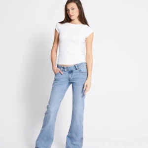 Ljusblå bootcut jeans med broderi - Säljer ett par ljusblå bootcut jeans med snyggt broderi på bakfickorna. Jeansen har låg midja och klassisk femficksdesign. Perfekta för dig som gillar en avslappnad men ändå trendig look.