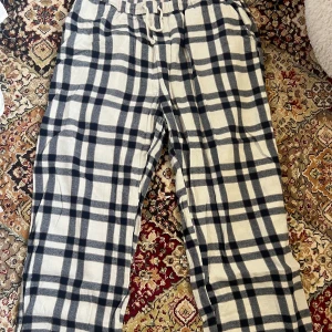 Rutiga mjukisbyxor från Lindex  - Mysiga mjukisbyxor i vitt och mörkblått rutigt mönster. Byxorna har elastisk midja med snörning och är tillverkade i mjukt bomullstyg! Storlek L på dessa ☺️🙏🏼Säljer då dessa inte kommer till användning längre, en defekt som syns är en liten fläck (visas på bild 2) det är inget man tänker på då den sitter lång ner på benet och tror den kan gå bort i tvätten om man använder fläckborttagning!!