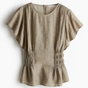 Beige blus med volang och smock - (inte min bild) Snygg beige blus med korta, vida ärmar och smockdetaljer i midjan som ger en markerad siluett. Blusen har volang nertill och är tillverkad i ett lätt, luftigt material som passar perfekt till varma dagar. Kommer inte skicka den till någon som inte följer mig. 