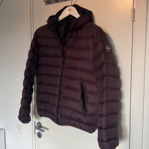 Colmar vårjacka - Säljer en snygg brun vinterjacka från Colmar i mycket bra skick. Jackan har en dragkedja framtill och en mysig huva. Perfekt för höst och vinter, håller dig varm och stilren. Storleken är herr M. Passar både till vardags och finare tillfällen.