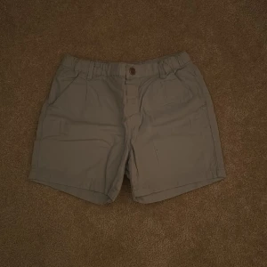 Ljusblå shorts från H&M - Säljer ett par ljusblå shorts från H&M i storlek EUR 134. De är tillverkade i 100% bomull och har en knapp framtill. Perfekta för en avslappnad stil.