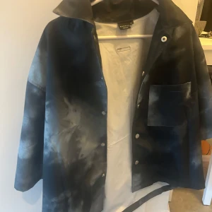 Svart och grå skjorta - Snygg svart och grå skjorta med ett unikt mönster. Jackan har en krage och knappar framtill. Storlek S men passar mer som XS.