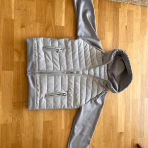 Grå Hybrid/Cardigan Jacka (Nyskick) - Tjena säljer denna cardigan jacka, fick fel storlek när jag köpte men fick en helt ny, därför säljer jag denna. Utöver det var materialet riktigt skönt och mjukt och jackan kändes kvalitativ överlag. Jackan är i helt nyskick. Storlek M, passar S-M också då den var mindre än sin storklek så passar S bra men också M.