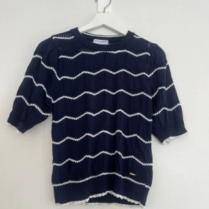 Mörkblå tröja från Holly & Whyte - Säljer en mörkblå tröja från Holly & Whyte med vita sicksack-ränder. Använd enbart ett fåtal gånger och är normal i storleken!