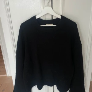 Svart stickad tröja från Gina  - Säljer en svart stickad tröja från H&M i storlek S. Tröjan har en klassisk design med rund hals och långa ärmar, perfekt för kyligare dagar. Den är mjuk och bekväm, idealisk för både vardag och avslappnade tillfällen.