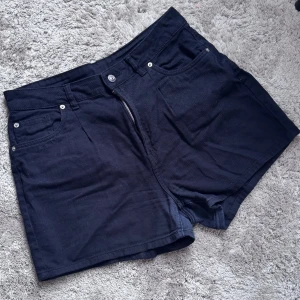 Svarta shorts från Divided - Säljer ett par svarta shorts från Divided. De har en klassisk femficksdesign med dragkedja och knapp framtill. Perfekta för en avslappnad stil.