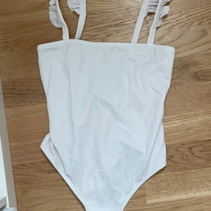 Vit baddräkt med volang - Superfin vit baddräkt från NA-KD, storlek S. 