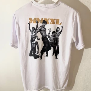 T-shirt med tryck - Snygg vit t-shirt med ett tryck på baksidan. Perfekt för en avslappnad stil. T-shirten har korta ärmar och en klassisk rund halsringning.