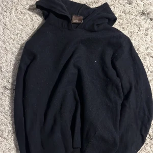 Mörkblå kashmir hoodie från Oscar Jacobson - Säljer en stilren hoodie från Oscar Jacobson i Babylon blue. Perfekt för en avslappnad stilren look. Den är tillverkad i merinoull ull och kashmir blandning och går att tvätta(i försiktig tvätt inställning). Passform är i xs och passar folk runt 170. Skriv vid funderingar!