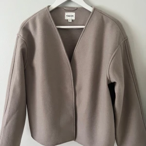 Beige kappa - Stilren beige vårkappa💗✨ Enkel design med v-ringning och långa ärmar. Perfekt för en minimalistisk look. Ej nopprig, knappt använd. Nypris: 600kr