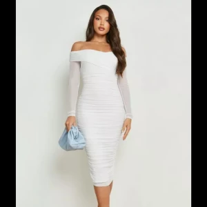 Vit offshoulder klänning/ studentklänning - Elegant vit offshoulder klänning med långärmade transparenta ärmar. Klänningen har en tight passform och är perfekt som studentklänning! Prislapp finns fortfarande på och den är aldrig använd. Finns minimal lite fläck som jag även tagit bild på men borde gå bort hur enkelt som helst! Skriv vid frågor ❤️