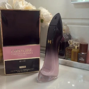 Good Girl Blush Elixir parfym 80ml - Good Girl Blush Elixir från Carolina Herrera i en ikonisk stilettklacksflaska med svart till rosa ombre och gulddetaljer. Lyxig och snygg design som verkligen sticker ut på parfymhyllan. 80 ml Eau de Parfum Elixir Natural Spray. Perfekt för dig som gillar eleganta dofter. Endast testsprejad 