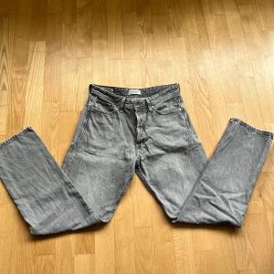 Grå jeans från Jack & Jones  - Snygga grå jeans från Jack & Jones, väldigt populära byxor, sköna och sitter fint på kroppen🙌 en defekt längst ner på jeansen (se bild)