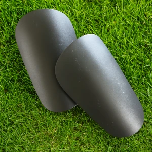 Svarta mini benskydd  - Säljer ett par svarta benskydd som är perfekta för fotboll. De har en slät och enkel design med rundade kanter och är tillverkade i lätt syntetmaterial. Passar dig som vill ha skydd utan att det känns klumpigt på planen.