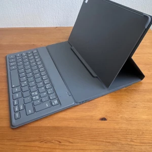 Samsung Galaxy Tab A7 Book Cover Keyboard - Säljer ett tangentbordsfodral till Samsung Galaxy Tab A7 Book Cover Keyboard . Det är ett "Book Cover Keyboard" som kombinerar ett skyddande fodral med ett Bluetooth-tangentbord.