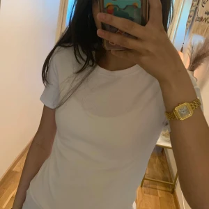 Vit ribbad t-shirt från FSBN Sister newyorker  - Snygg vit t-shirt från FSBN Sister i storlek M. Modellen är ribbad med rund hals och korta ärmar, vilket ger en clean och fräsch vibe. Perfekt att styla med jeans eller shorts. Materialet känns mjukt och skönt mot huden.