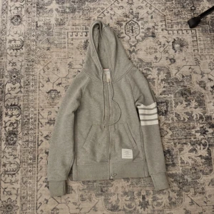 Thom Browne Zip Hoodie - Tjena! Säljer denna tvärfeta Thom Brown zipen i storlek 0 vilket motsvarar S. Tyvärr inget kvitto då den är köpt på andrahand, den är i fint skick!