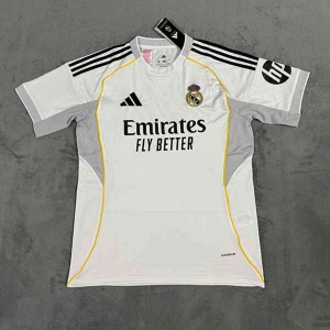 Real Madrid 25/26. Mbappe på ryggen.  - Ny. Snygg Real Madrid fotbollströja från Adidas i vitt med svarta detaljer och gula linjer. Kortärmad med klubbmärke på bröstet och Emirates Fly Better-tryck. Svarta ränder på axlarna och grå paneler på sidorna. Tillverkad i lätt, ventilerande material.