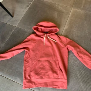 Polo Ralph lauren hoodie  - Säljer en chill rosa hoodie från Polo Ralph Lauren med klassisk blå logga på bröstet. Tröjan har huva med vita snören, stor magficka och långa ärmar. Mjuk bomullskvalitet som är skön att ha på sig. Perfekt för dig som gillar stilren streetwear. Skick 9/10 pris kan diskuteras vid snabb affär✅ modellen är 180cm och väger 73kg