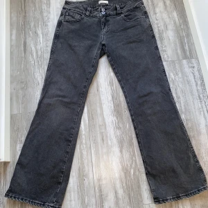 Grå/svarta low waist bootcut jeans från Gina tricot - Snygga grå/svarta jeans från gina med bootcut passform och snygga fickor. ❤️ Jag säljer jeansen för att de är lite stora och får därför ingen användning av dem. Jeansen är sydda lite vid den vänstra fickan men det är inget man märker när dom är på!