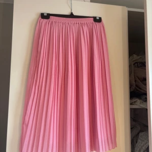 Rosa midi-kjol - Säljer rosa midi-kjol från BikBok. Knappt använd och i superbra skick.