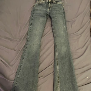 Bootcut jeans från Gina Tricot  - Snygga mörkblå bootcut jeans från Gina med klassisk femficksdesign i strl 32. Jeansen är lågmidjade och innerbenslängden är cirka 78cm. Lappen på baksidan är lite skrynklig och texten där är delvis urblekt men det syns knappt när man har jeansen på (Se bild 5) Nypris 499kr. Hör gärna av er med frågor:)