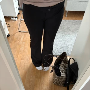 Svarta kostymbyxor - Snygga svarta kostymbyxor från Ginatricot. Byxorna har en klassisk midja och stängs med knapp och dragkedja framtill. Materialet är mjukt och har en lätt stretch för skön passform. Små defekter ser du på de två sista bilderna, skriv för fler bilder🩷