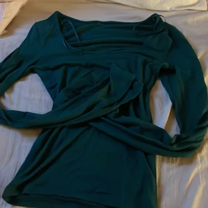 Mörkgrön långärmad tröja -  mörkgrön långärmad tröja med rund halsringning. 