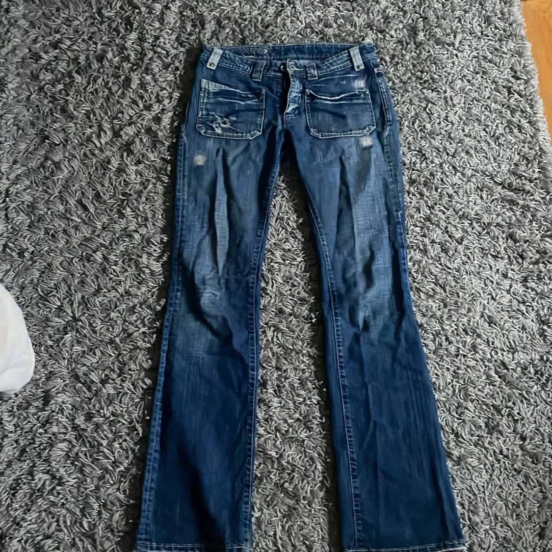 Blå jeans med slitningar
