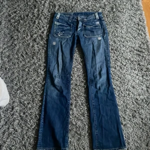 Blå jeans med slitningar - Intressekoll på dessa unika blå jeans med slitningar. De är low bootcut och har super snygga fickor både fram och bak. Säljer då de är för stora för mig. Midjemått: 38, innerbenslängd: 82 och ytterbenslängd: 105  storlek står inte men skulle säga S - M 