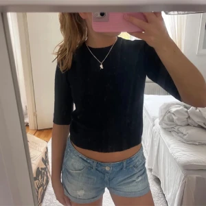Mörkblå stickad tröja från Zara - Använd 1 gång! Säljer en svart stickad tröja från Zara med trekvartsärm och rund halsringning. Tröjan är croppad och har en enkel, stilren design som passar perfekt till jeans eller kjol.