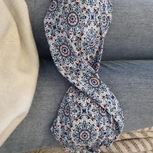 Mönstrad bikiniöverdel från Firefly - Säljer en snygg bikiniöverdel från Firefly i storlek S. Den har ett blått, vitt och rosa mönster med spännande geometriska former. Bikinin har en smidig knäppning bak och är perfekt för sommardagar vid stranden eller poolen.