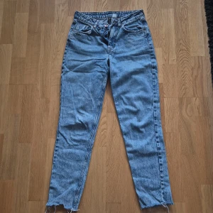 Blå raka jeans  - Säljer ett par klassiska blå jeans med raka ben och råa, fransiga benslut. Jeansen har hög midja. Sitter bra på mig som är 154cm. Säljer pga använder ej.