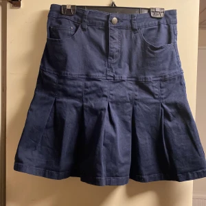 Mörkblå jeanskjol - Säljer en söt mörkblå jeanskjol med markerade veck framtill. Perfekt att styla med både pösiga kläder som en hoodie eller finkläder som en topp 💕