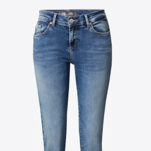 Mid rise Blå bootcut jeans  - Säljer ett par klassiska blå bootcut jeans med snygg tvätt och orangea sömmar. Jeansen har fem fickor, normal passform och är tillverkade i denim. Perfekta för dig som gillar en tidlös stil med lite extra edge. Storlek w28/34💕