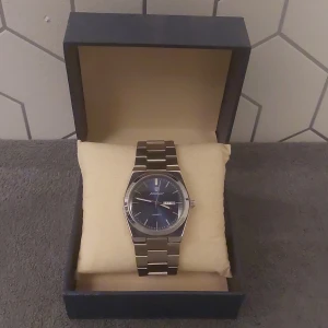 Marinblå Klocka  - Stilren klocka i silver med marinblå urtavla. || följer med extra länkbitar så man kan ändra storlek || helt ny || boxen medföljer inte 