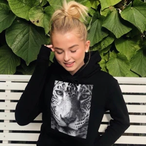 Svart hoodie med leopardmotiv - Säljer en svart hoodie med stort tryck av ett leopardansikte på bröstet. Tröjan har huva med dragsko och en stor magficka framtill. Första bilden är inte min! Det går att diskutera priset💕💕