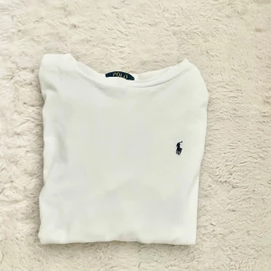 Vit långärmad Ralph Lauren Tröja - Säljer nu en tröja av Ralph Lauren. Tröjan är vit med blått märke. Storleken är 14-16år så ungefär XS/S, Skriv vid minsta fundering.
